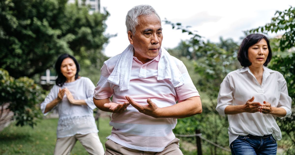 Seniors practicing tai chi in a park, focusing on balance and coordination to improve mobility and health.